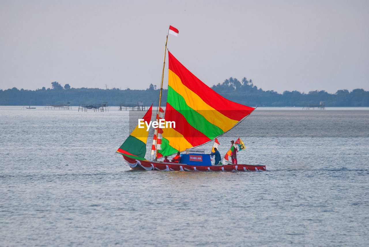 BOAT SAILING ON SEA AGAINST CLEAR SKY