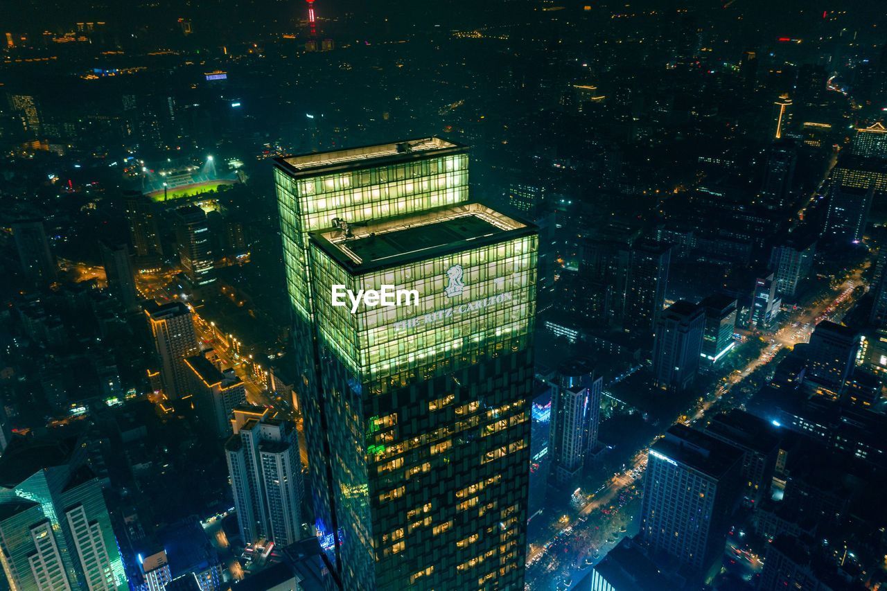 HIGH ANGLE VIEW OF ILLUMINATED CITY BUILDINGS AT NIGHT