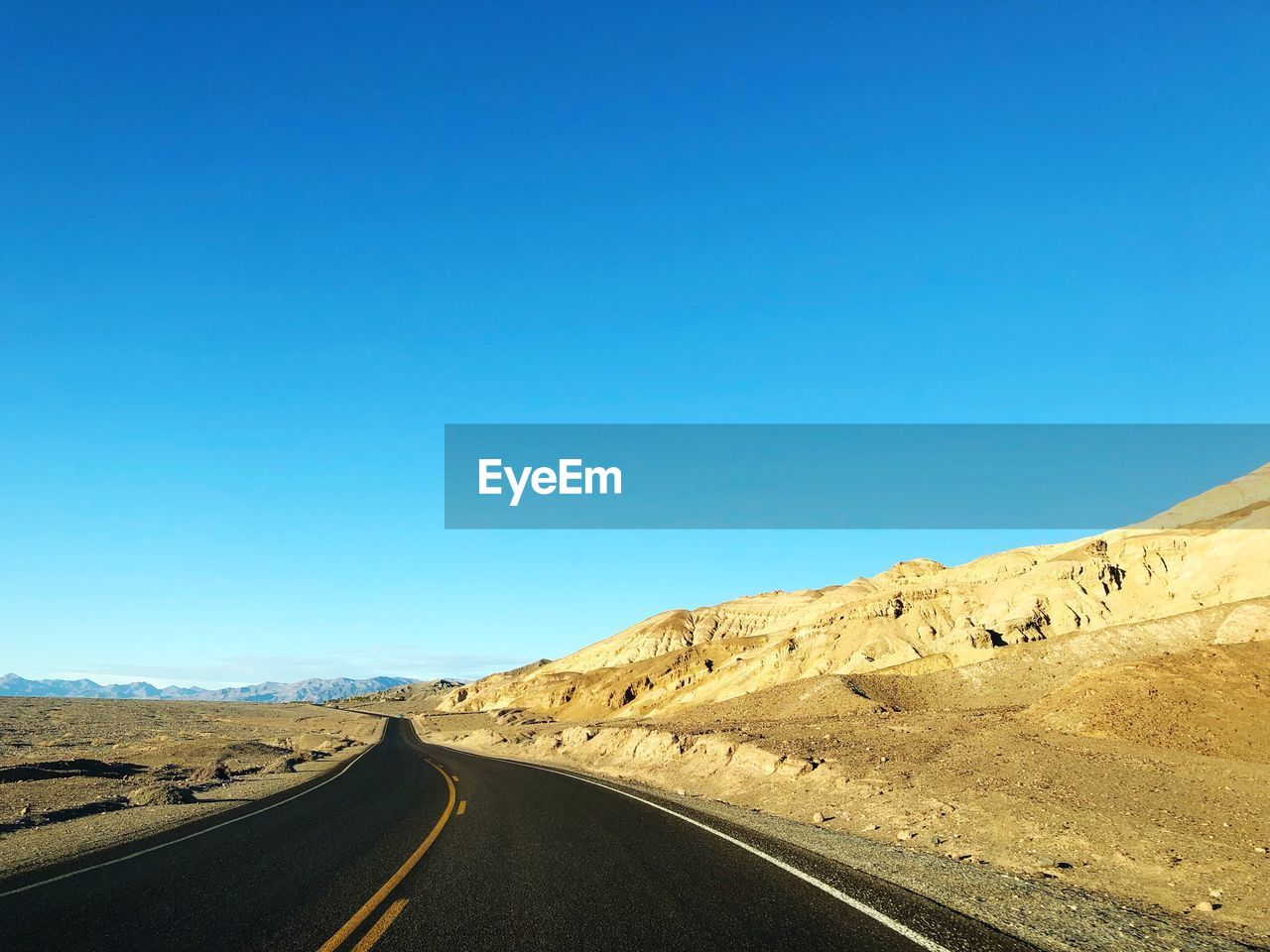 Scenic view of road against clear blue sky