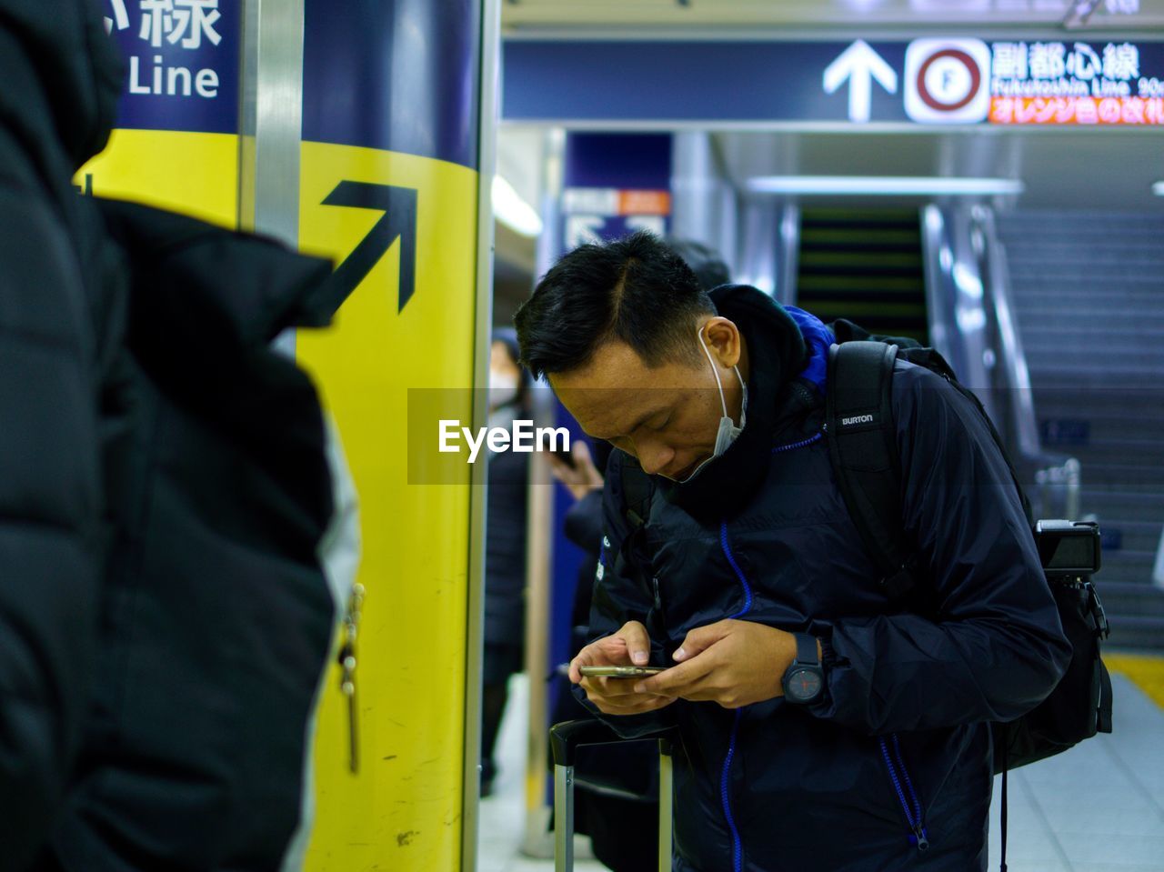 Man using phone at subway station