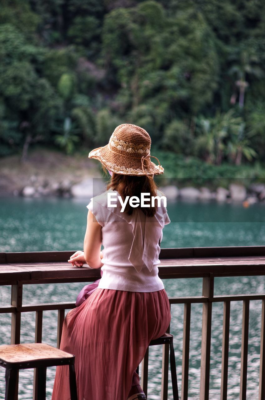 Rear view of woman standing by railing