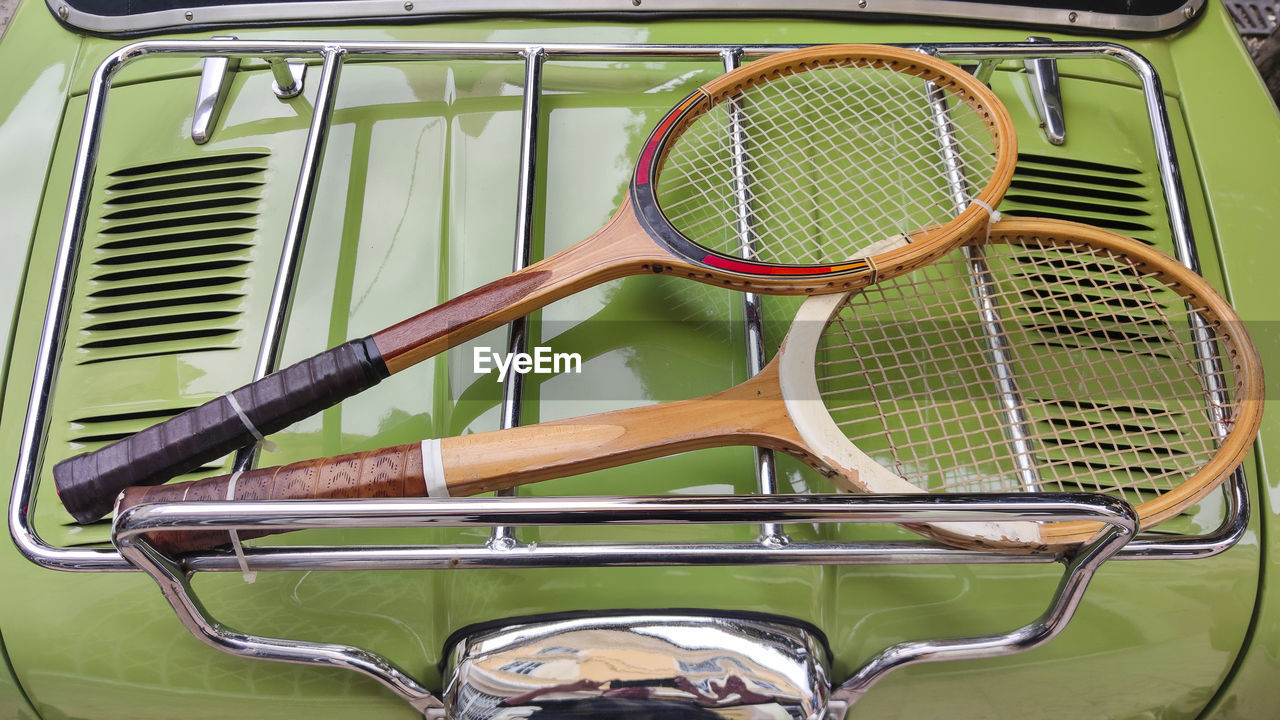 tennis, racket, sports equipment, tennis racket, vehicle, luxury vehicle, mode of transportation, wheel, sports, no people, transportation, car, land vehicle, string, metal, day, green, motor vehicle