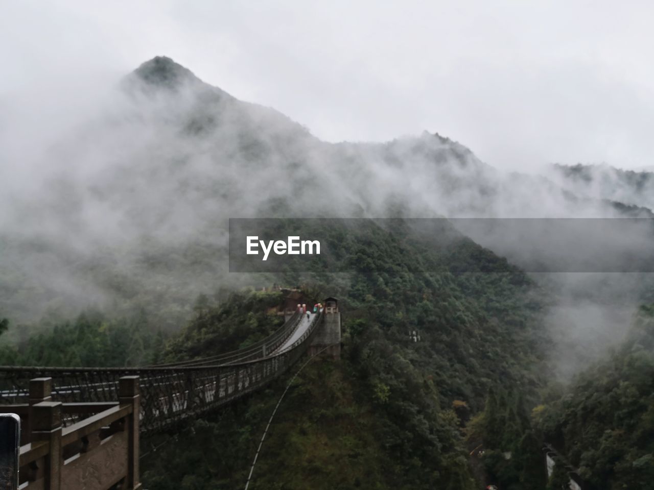 Bridge over mountain against sky