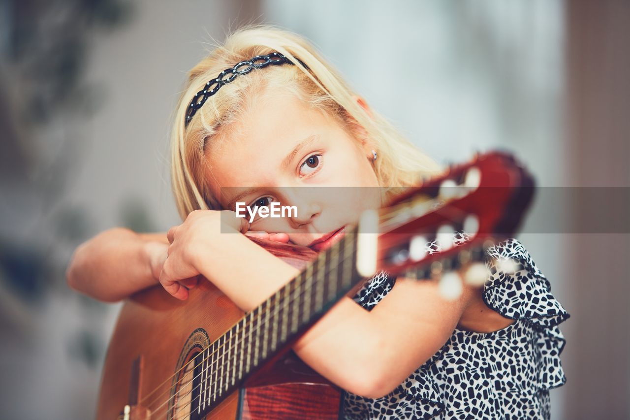 Close-up of girl playing guitar at home