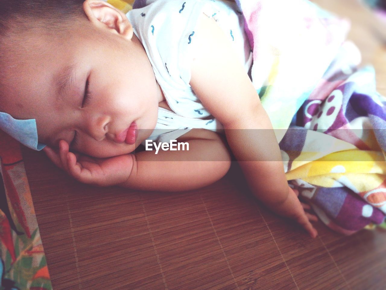 Close-up of baby sleeping on bed at home