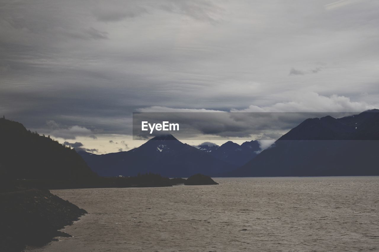 LAKE BY MOUNTAINS AGAINST SKY