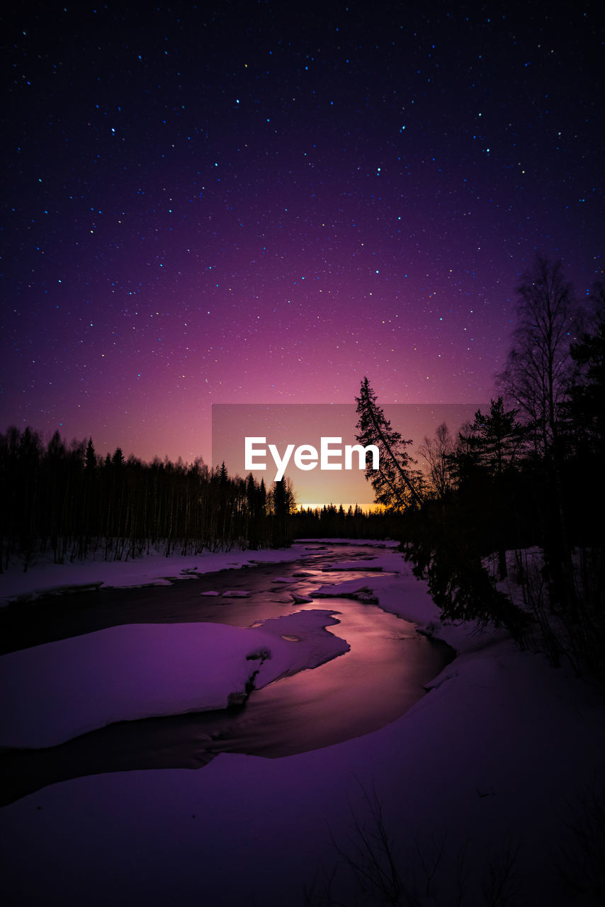 Scenic view of frozen lake against sky at night