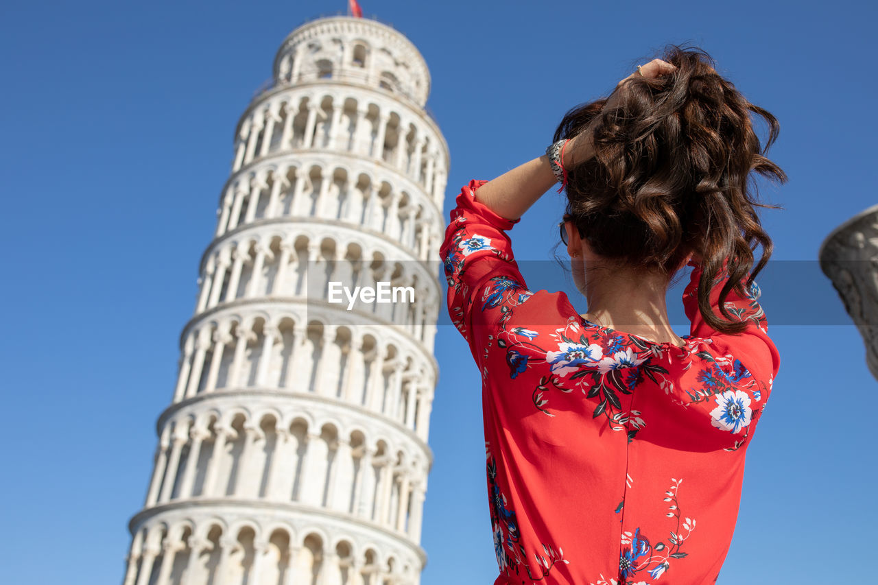 Woman standing against leaning tower of pisa