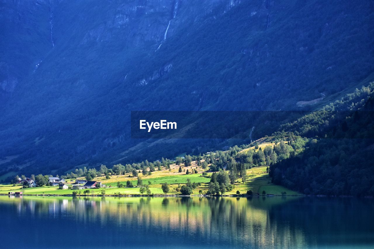 Scenic view of lake by buildings against mountain