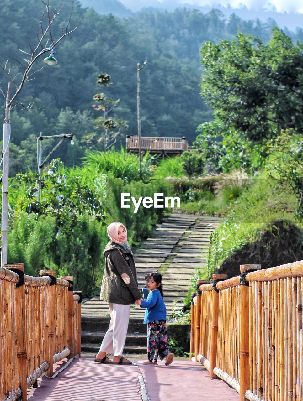 Rear view of two people walking on footpath