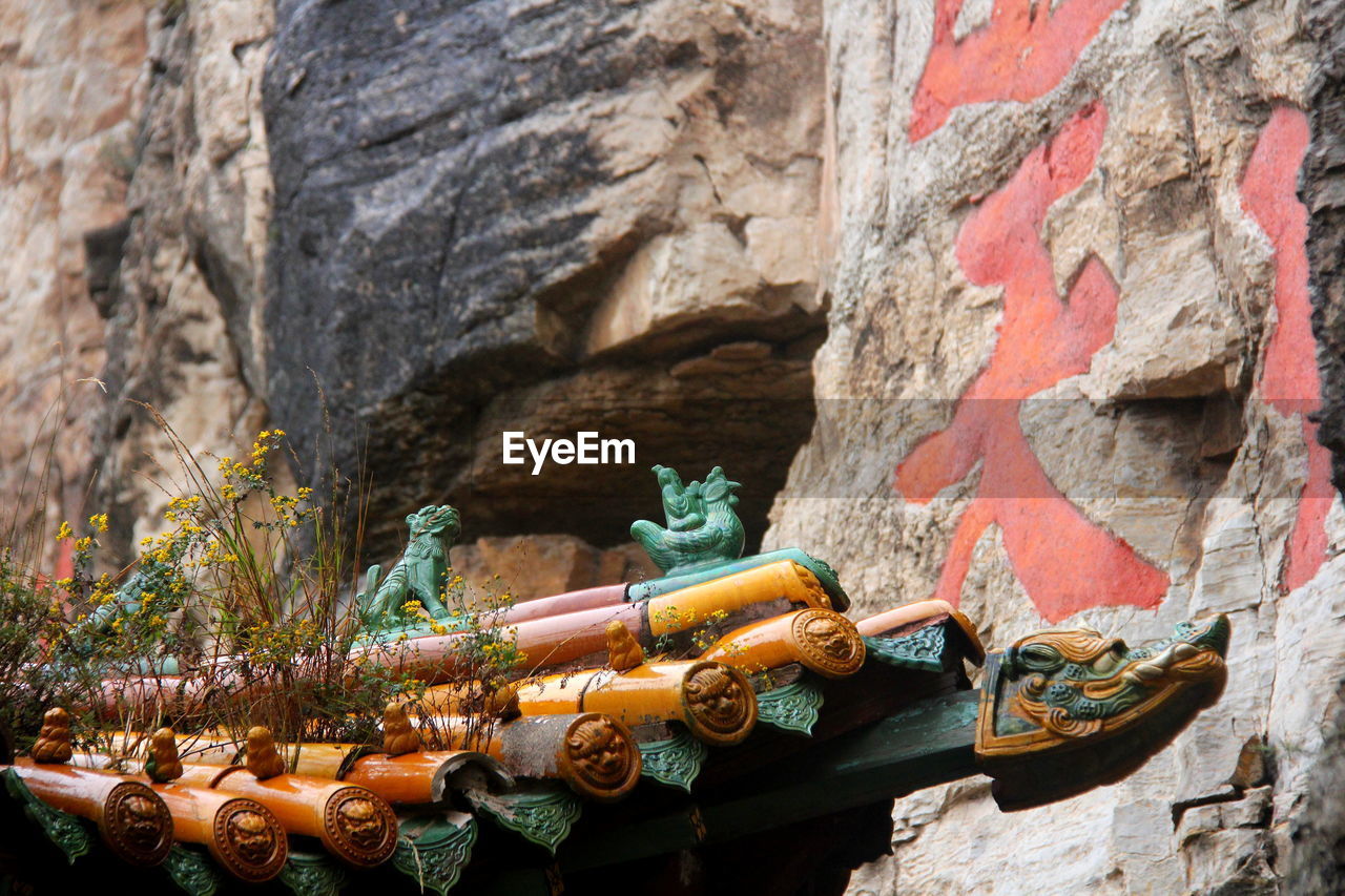 High section of traditional building against rock formation