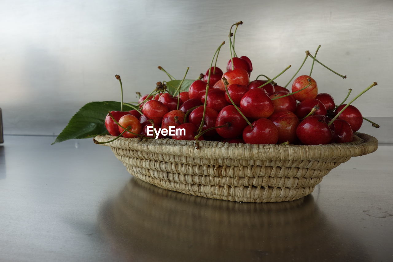 Close-up of cherries in wicker basket on table