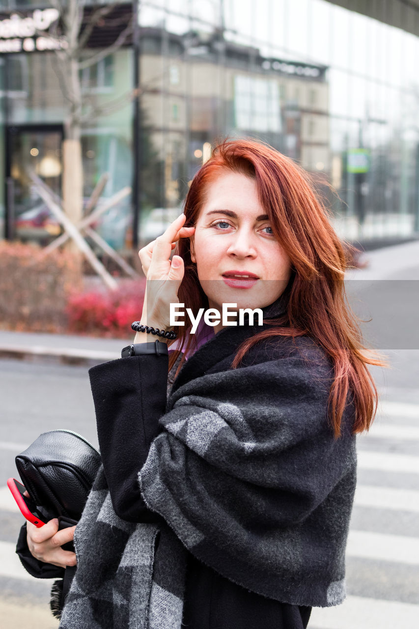 Attractive confident young woman is walking at the downtown district. 