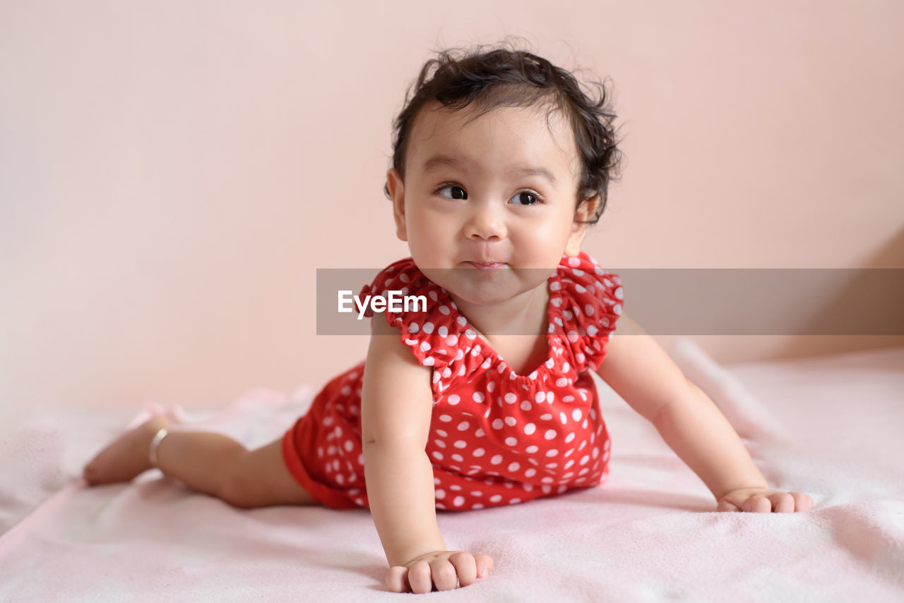 Portrait of cute girl lying on bed