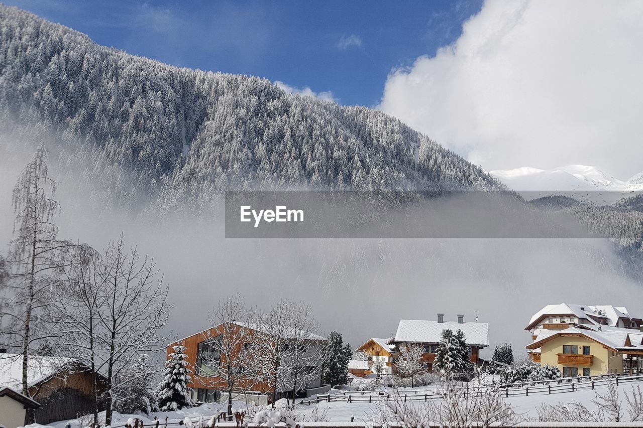 SNOW COVERED LANDSCAPE AGAINST MOUNTAIN RANGE