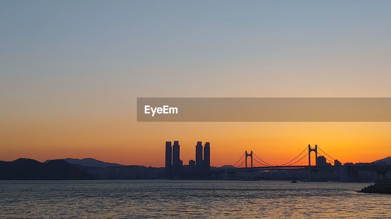 SUSPENSION BRIDGE OVER SEA DURING SUNSET