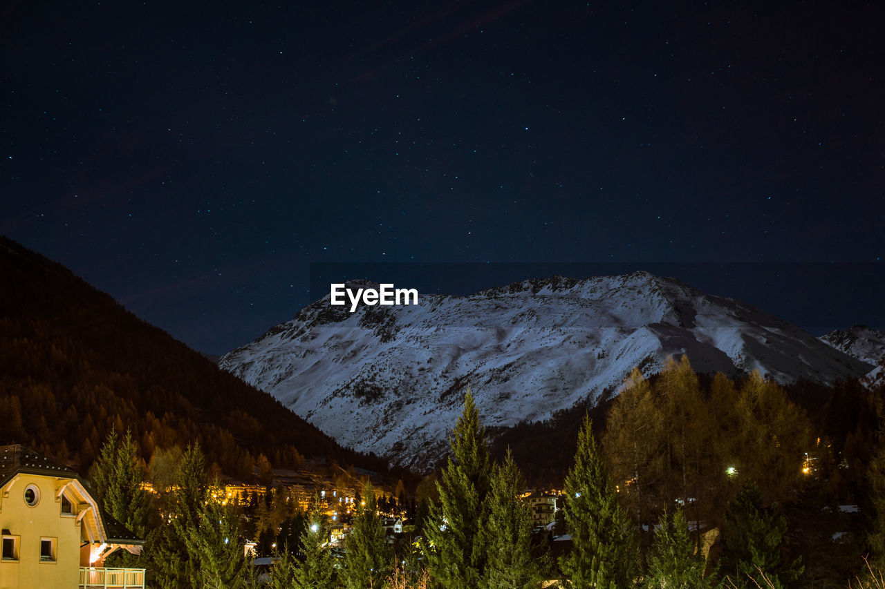 Scenic view of snowcapped mountain against sky at night