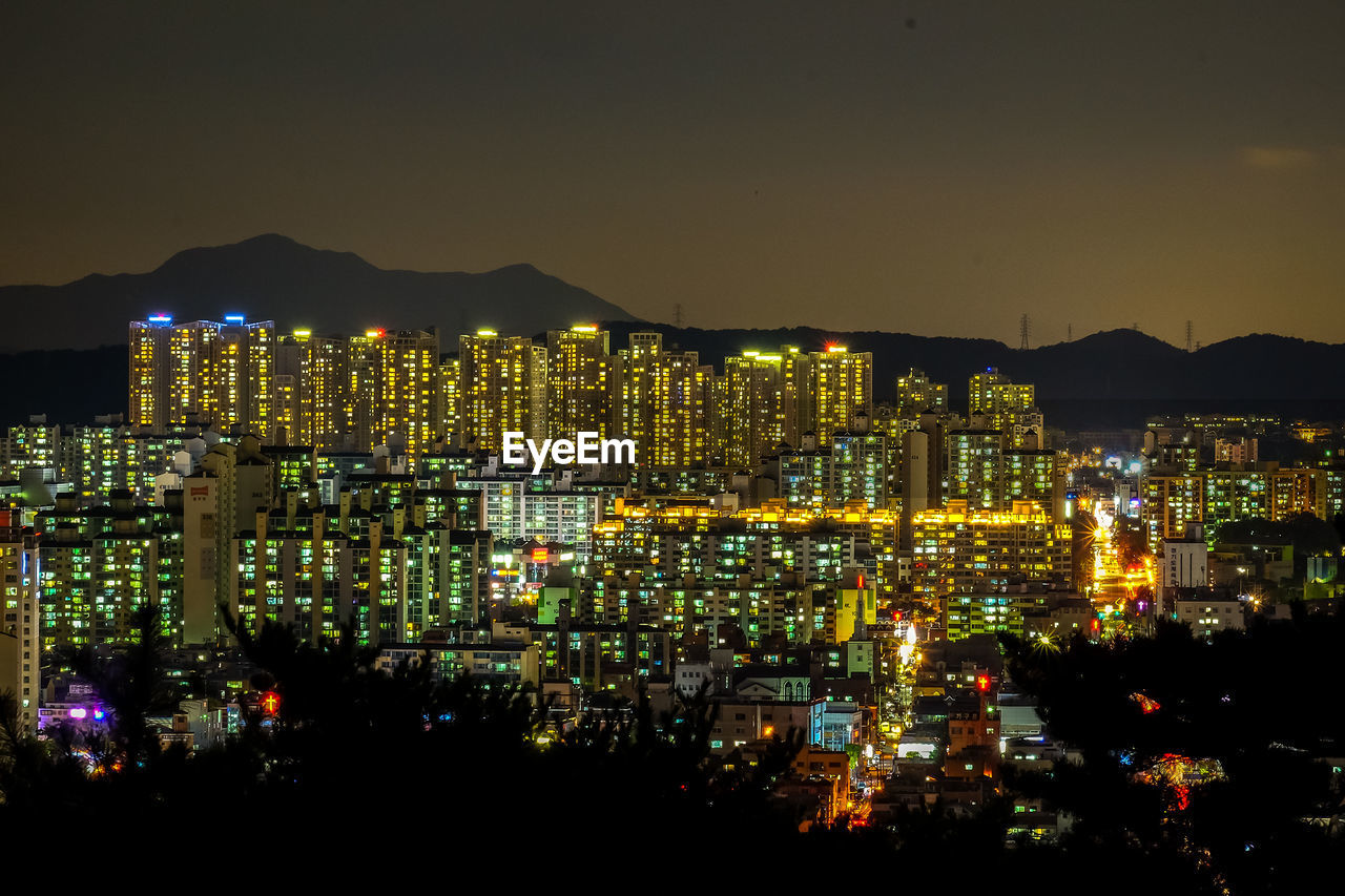 Illuminated cityscape against clear sky at night