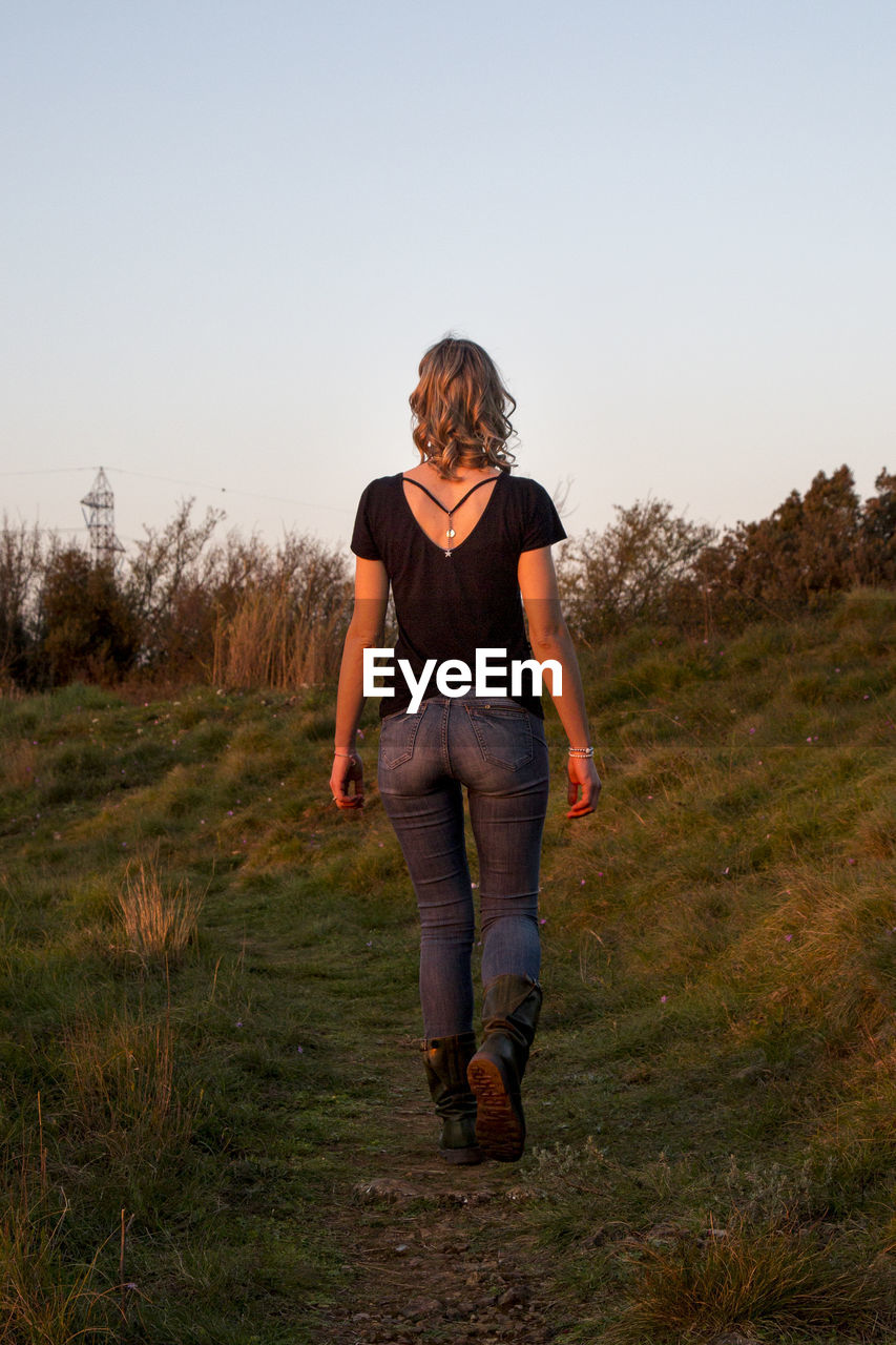 FULL LENGTH OF TEENAGE GIRL STANDING ON FIELD
