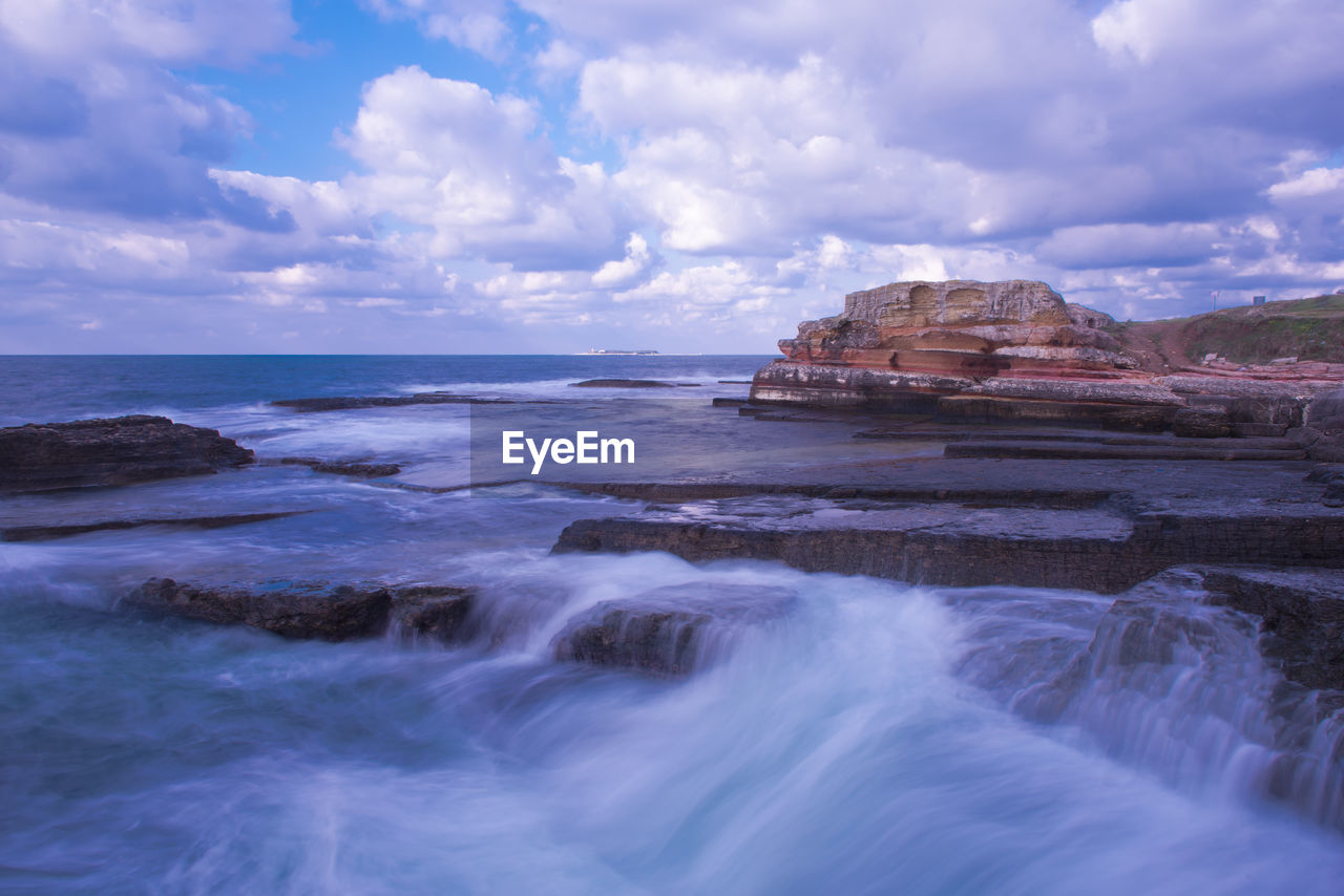 Scenic view of sea against cloudy sky