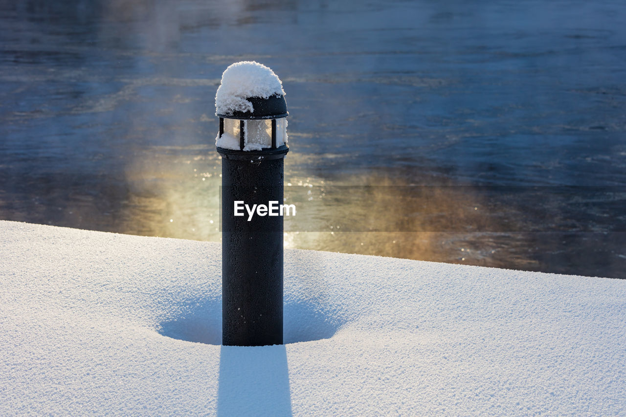 Frosty lamp post on snowy pier on a cold winter day