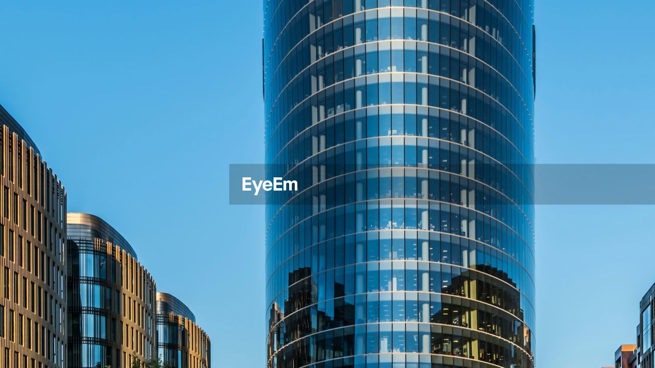 Low angle view of reflection on office building against sky