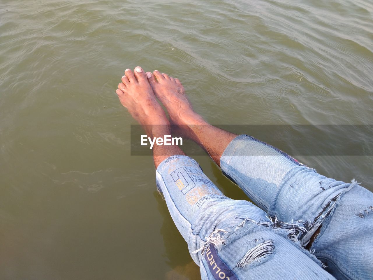 LOW SECTION OF PERSON LEGS IN WATER