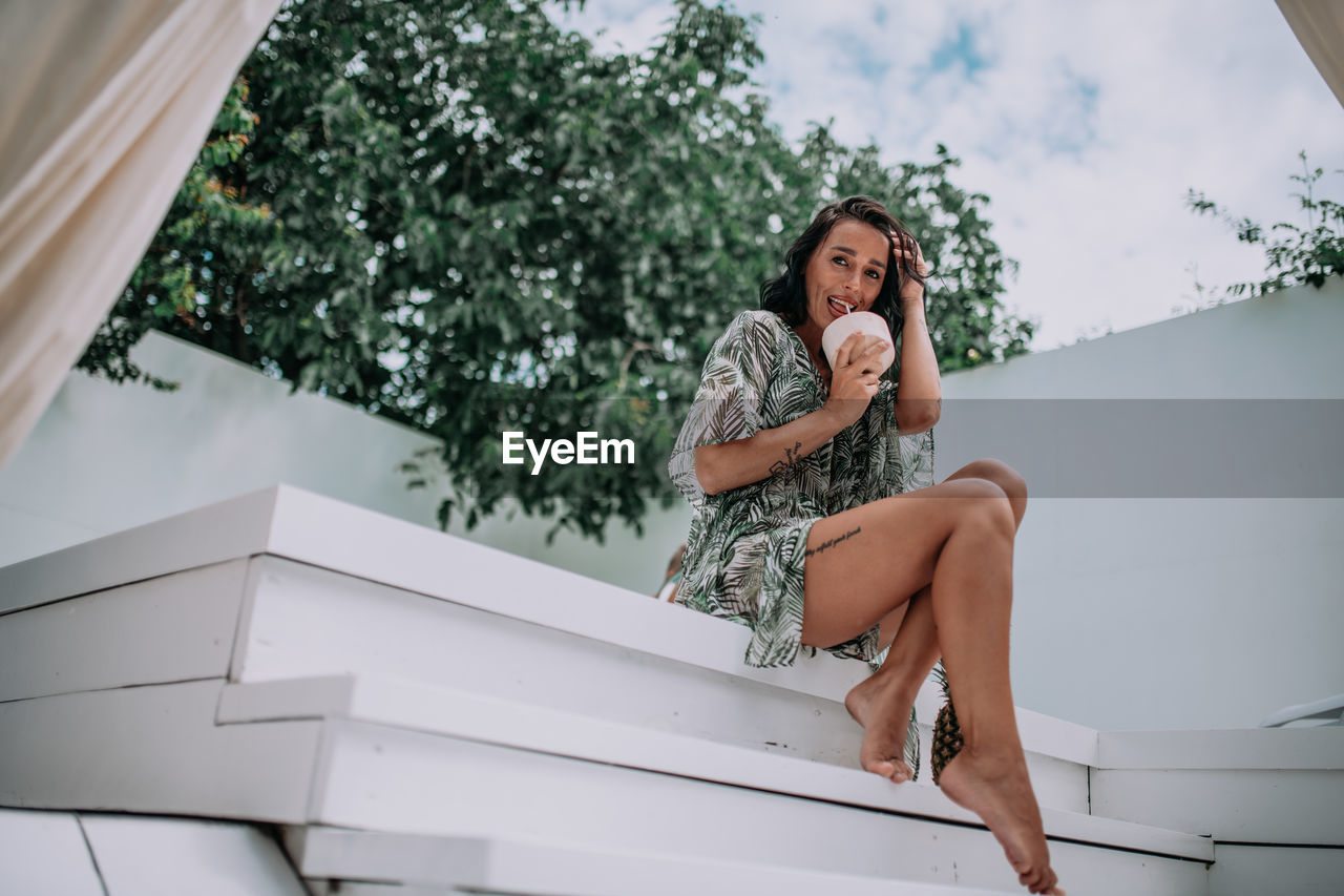 Low angle view of woman sitting outdoors