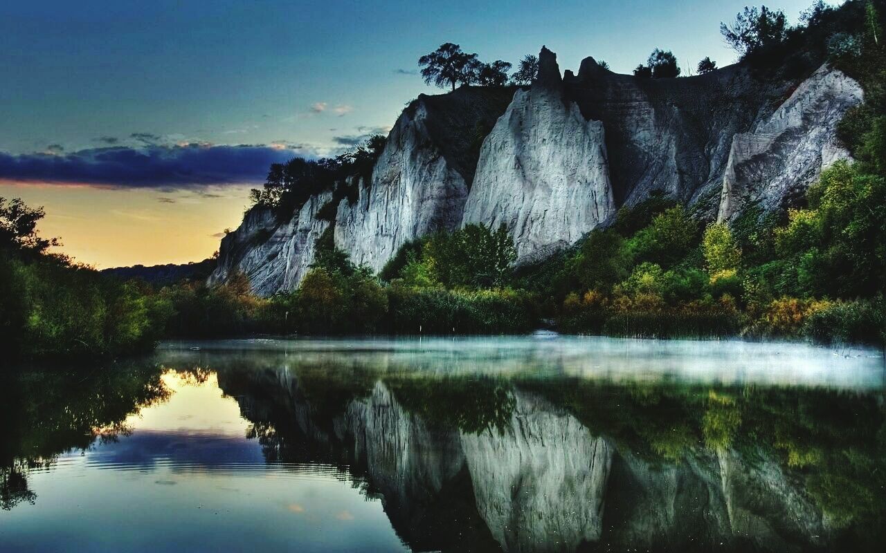 Scenic view of lake against sky at sunset