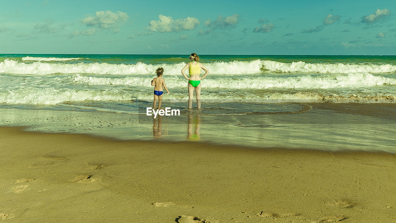 PEOPLE ON BEACH AGAINST SKY