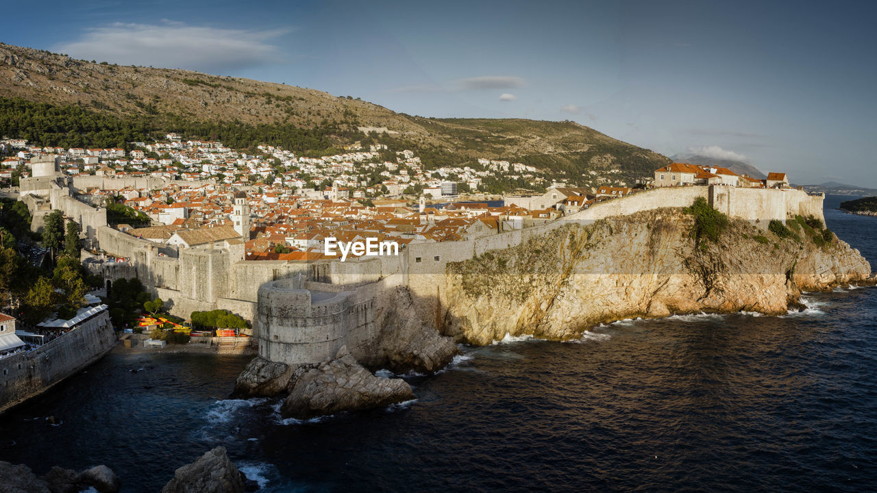 SCENIC VIEW OF RIVER BY BUILT STRUCTURES AGAINST SKY