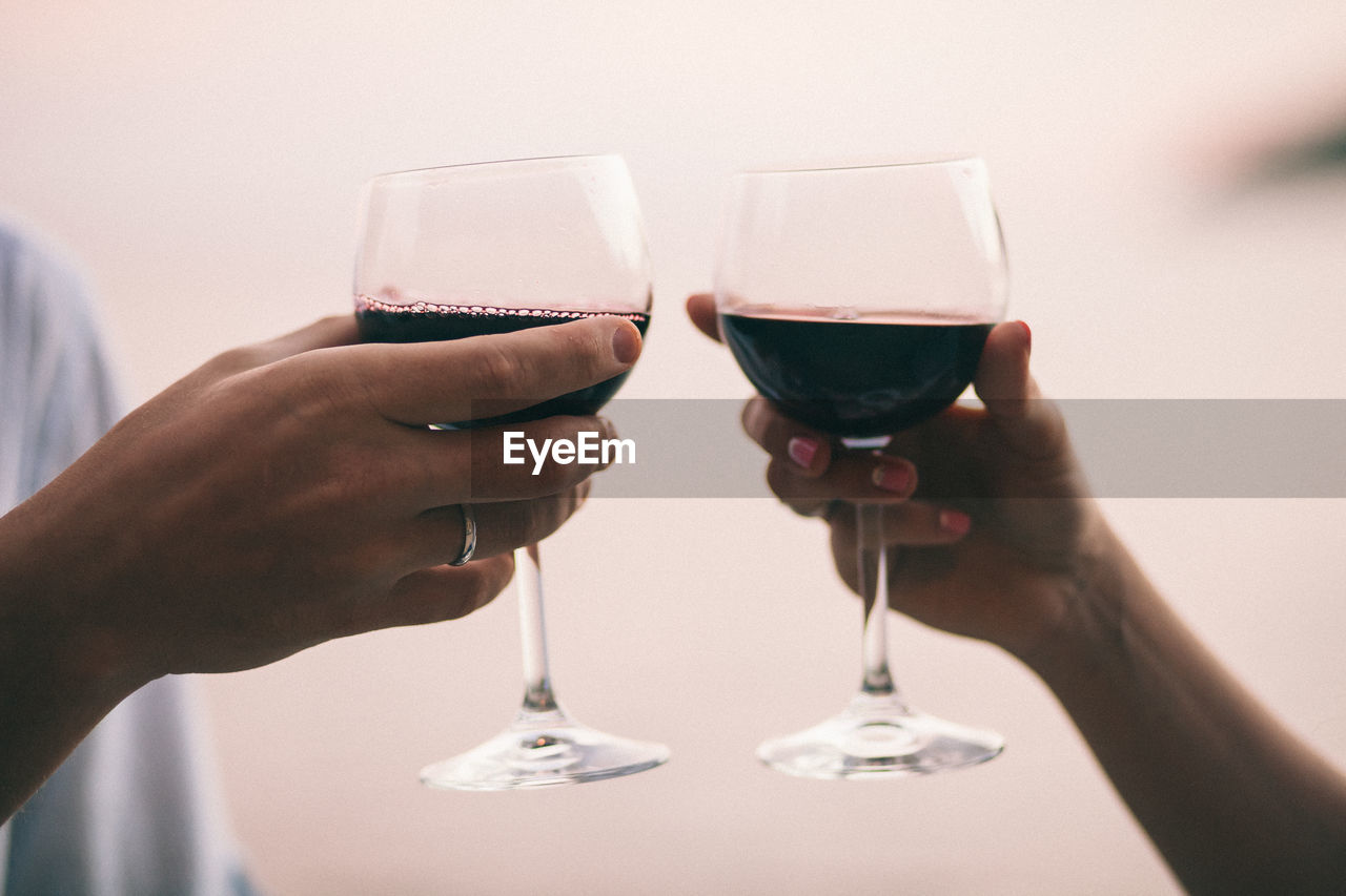 Close-up of hands holding wineglasses