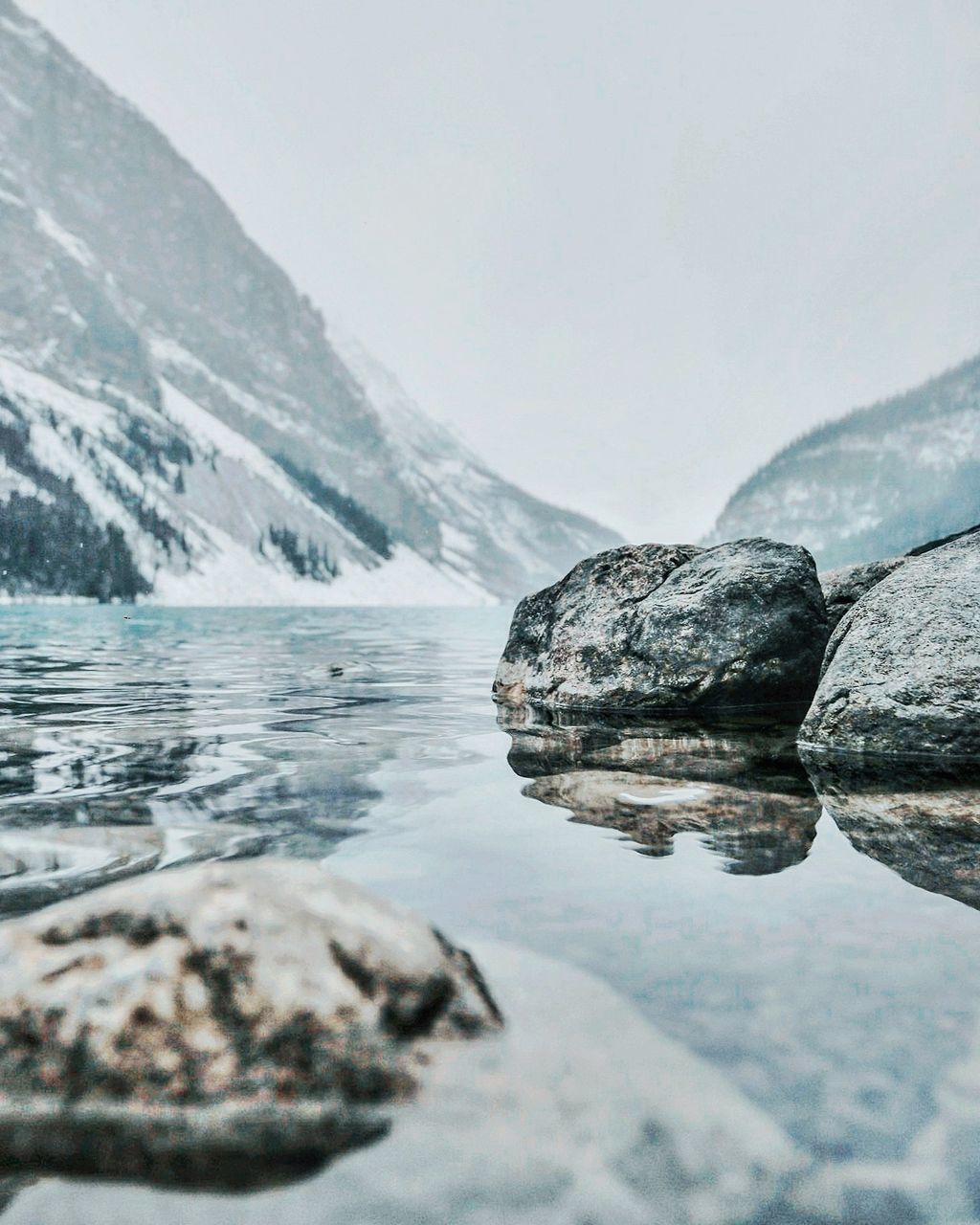 Scenic view of lake by mountain against sky