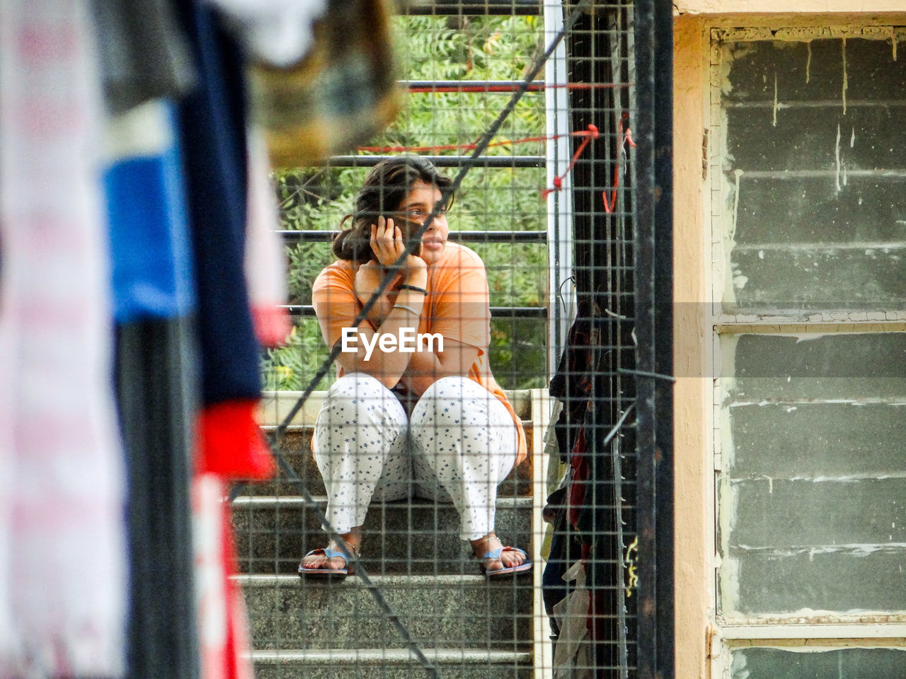 Woman talking on phone while sitting on steps