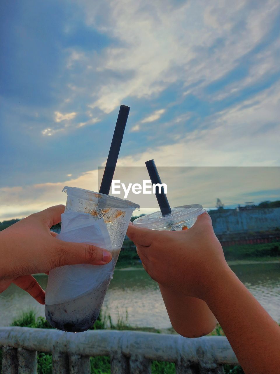 sky, blue, hand, sea, holding, cloud, vacation, one person, nature, food and drink, adult, refreshment, leisure activity, water, morning, day, women, lifestyles, drink, outdoors, wind, food, summer, limb