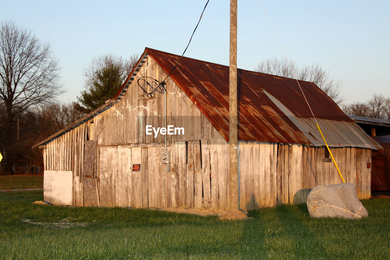 BARN ON FIELD AGAINST SKY