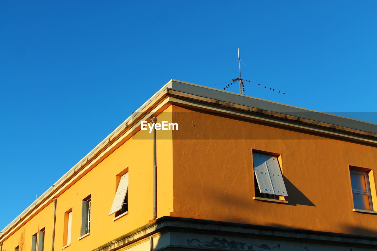 Low angle view of building against clear blue sky