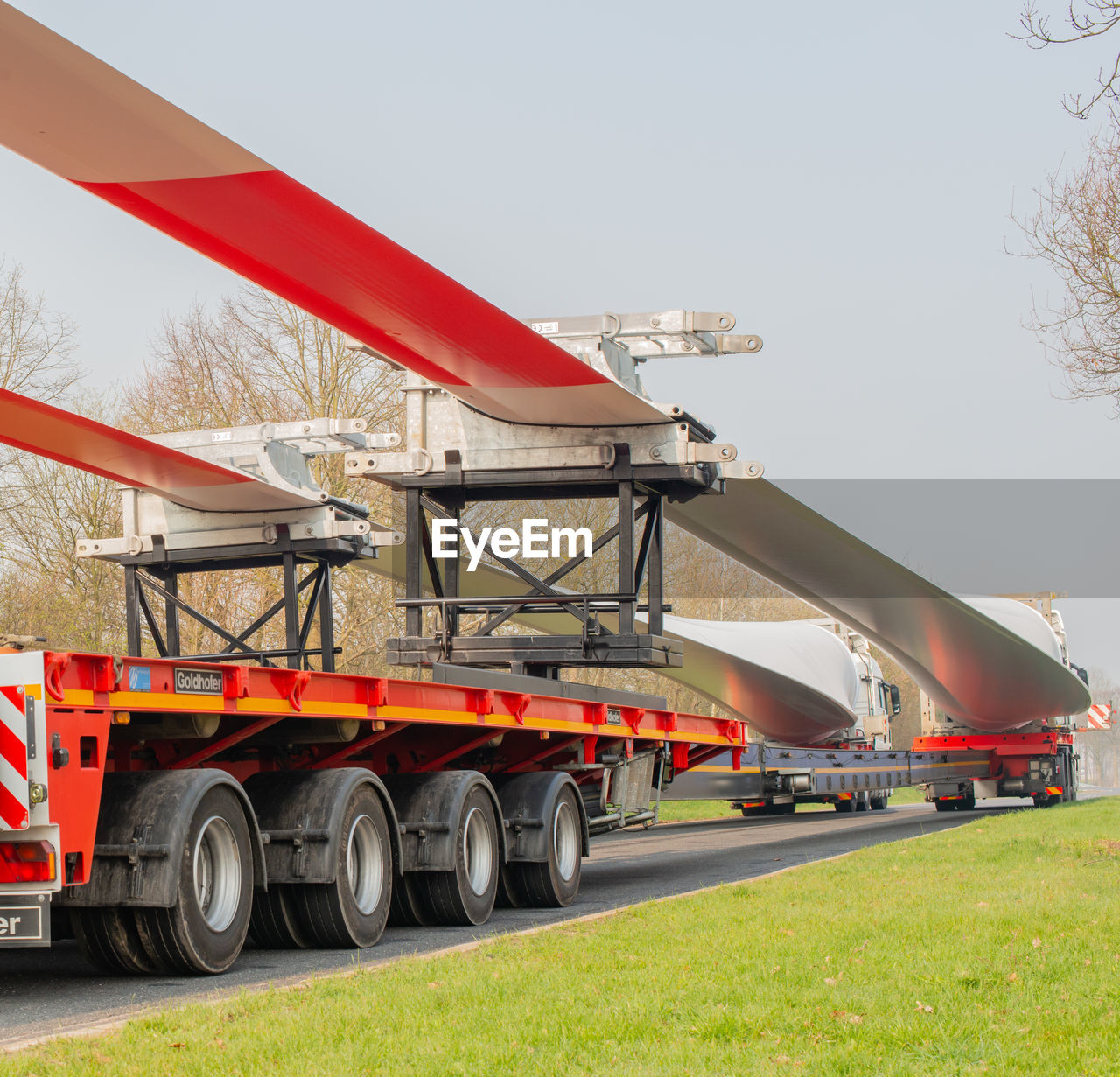 RED CART ON ROAD AMIDST FIELD