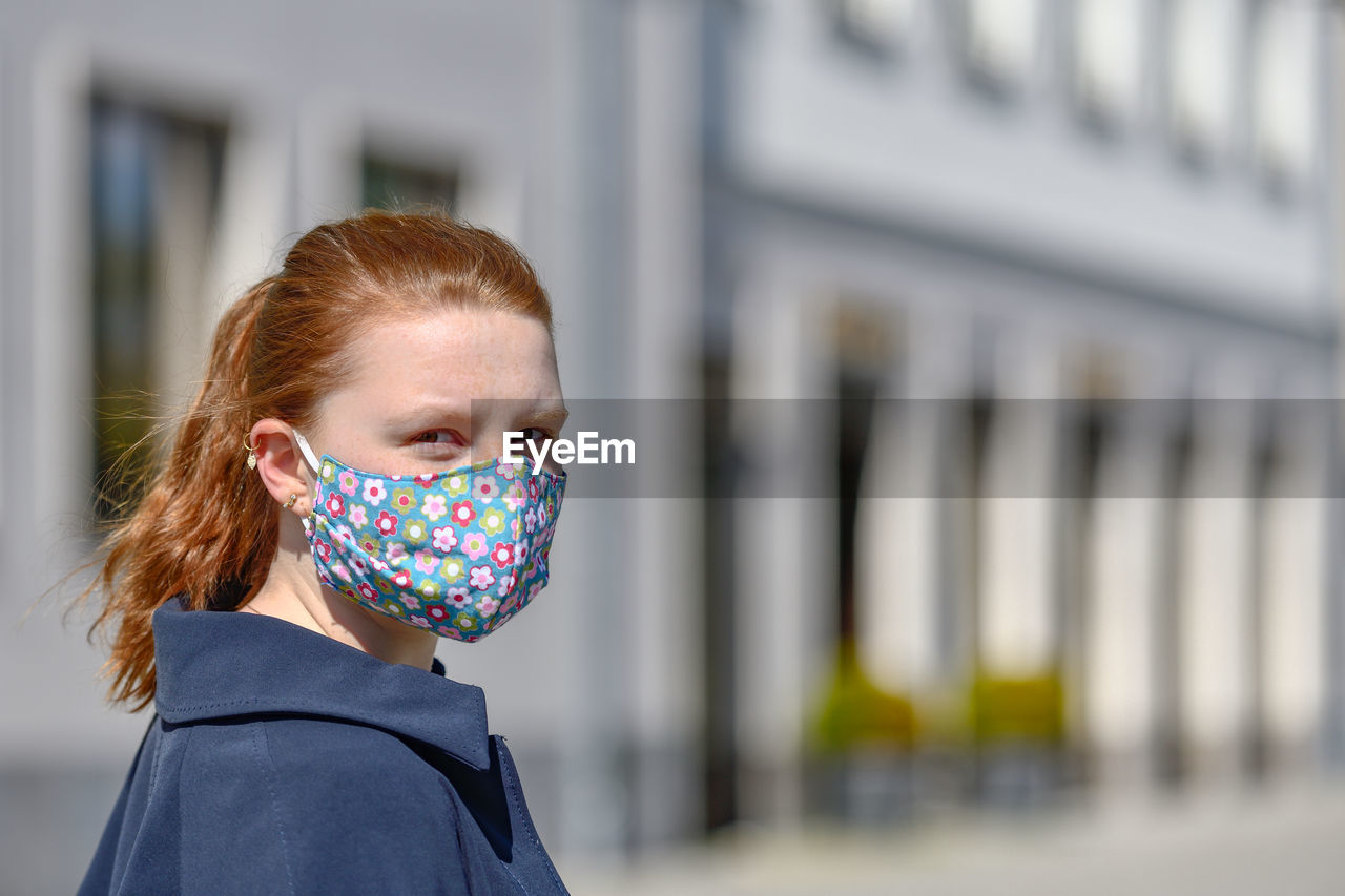 Portrait of woman wearing mask while standing outdoors