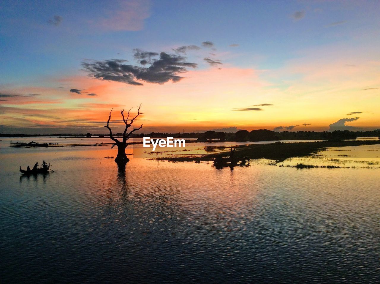 SILHOUETTE TREES BY SEA AGAINST SKY DURING SUNSET