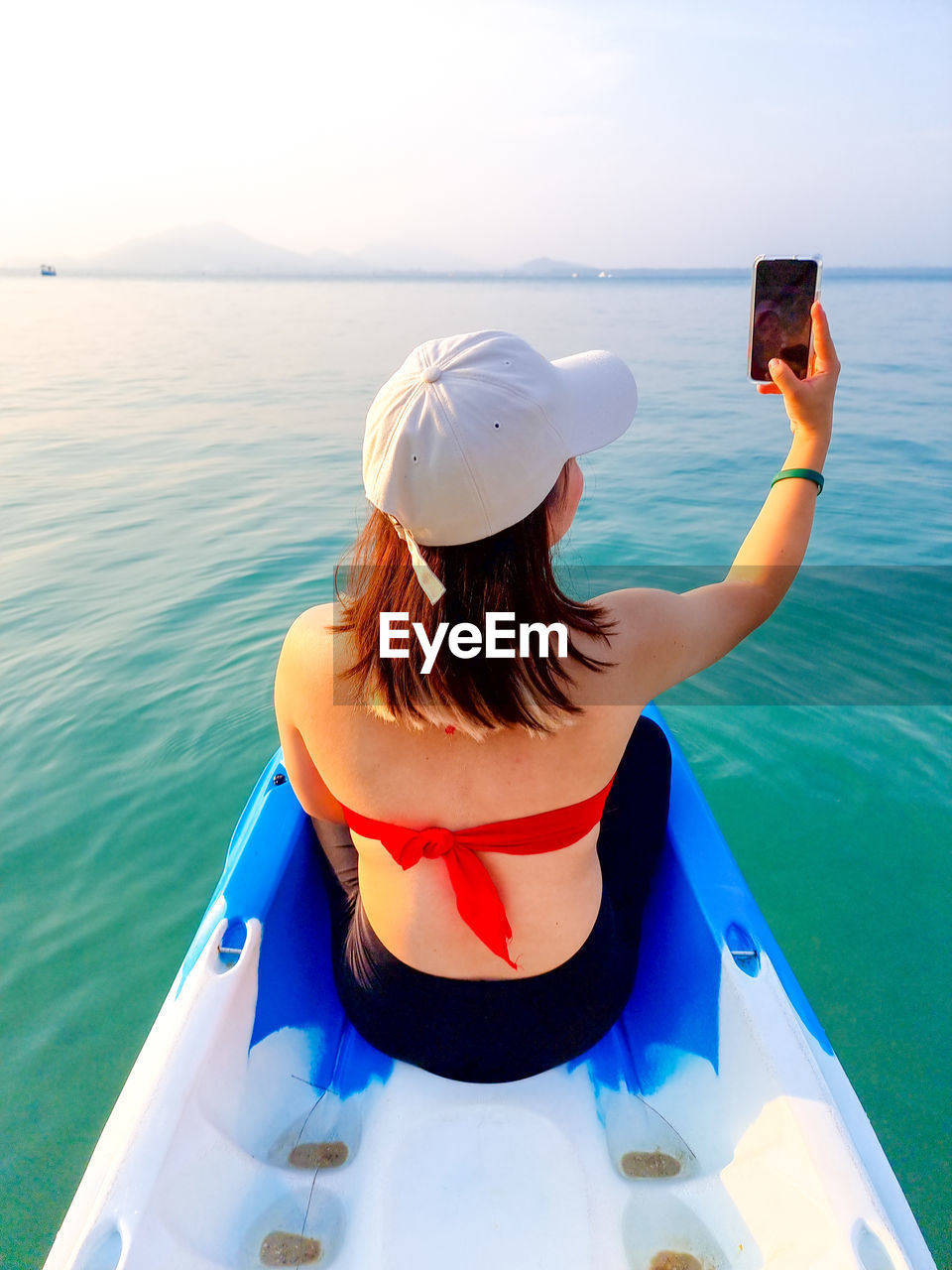 Rear view of woman in boat in sea