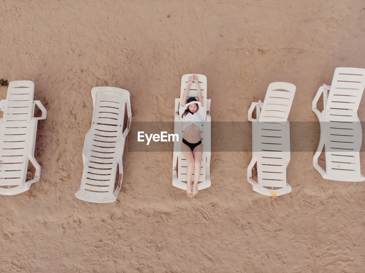 HIGH ANGLE VIEW OF CHAIRS IN SAND