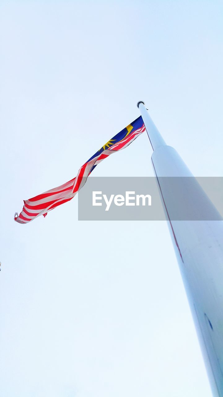 Low angle view of flags against clear sky