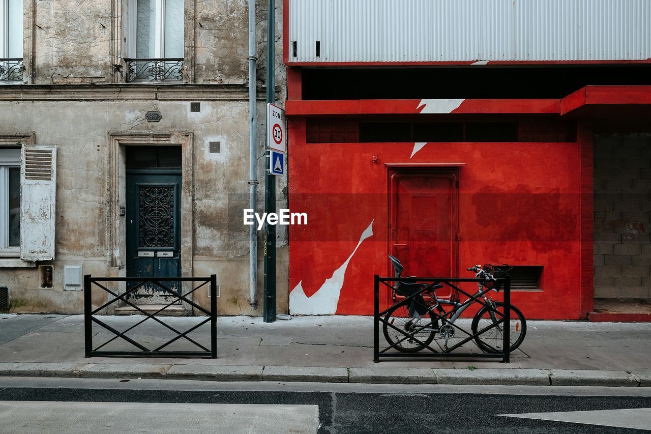 Bicycle parked on sidewalk against buildings