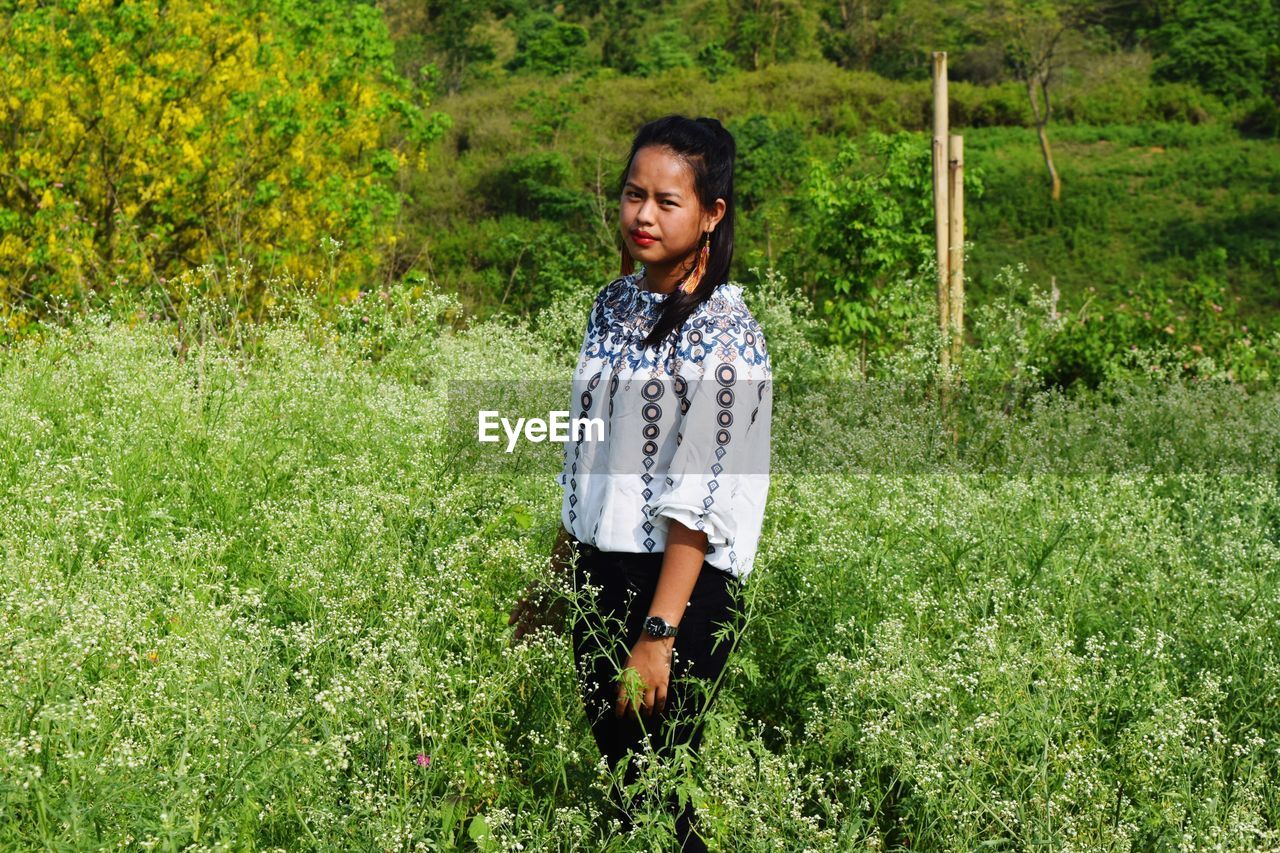 Portrait of woman standing on field