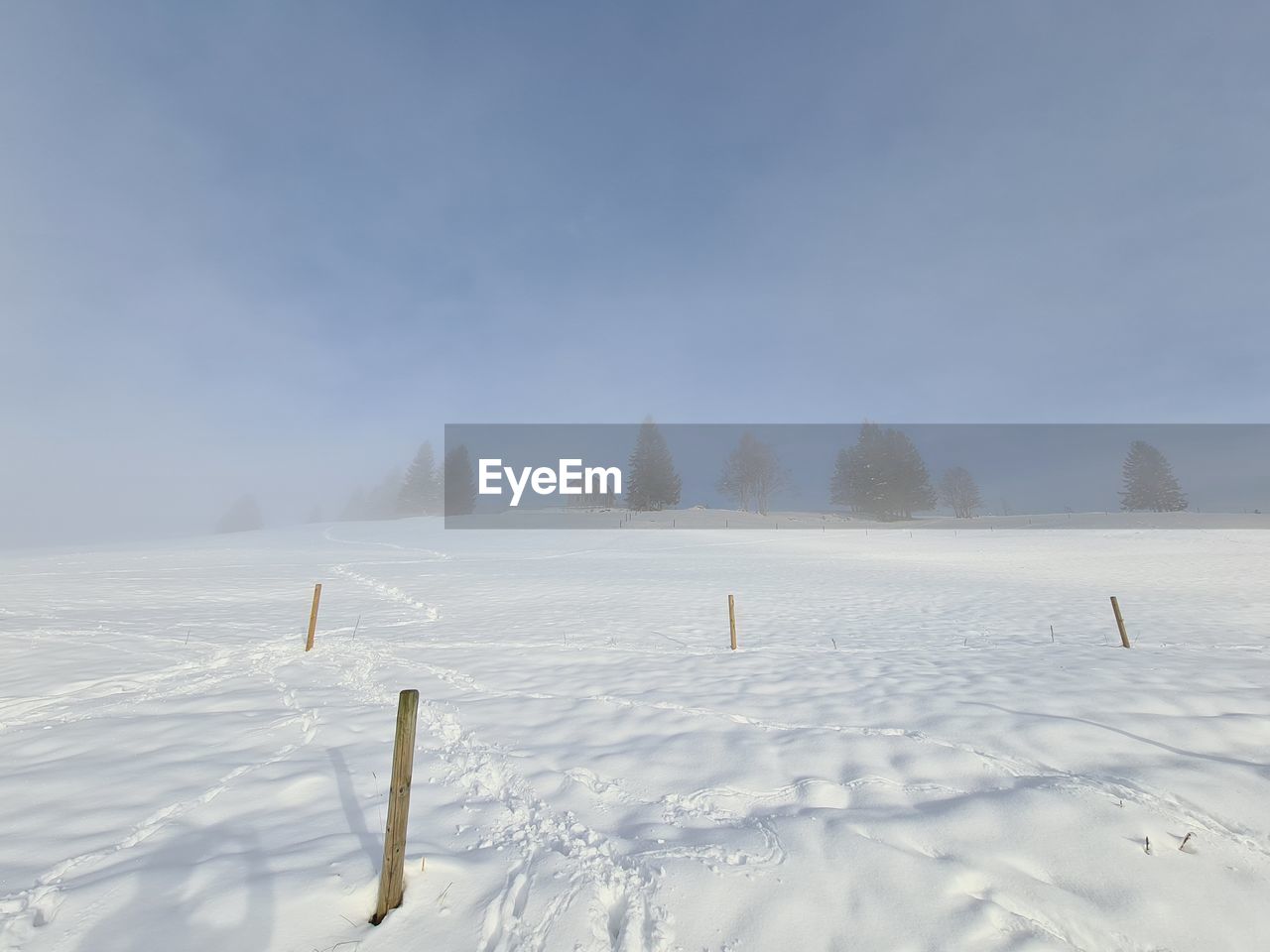 Scenic view of snow covered field against sky