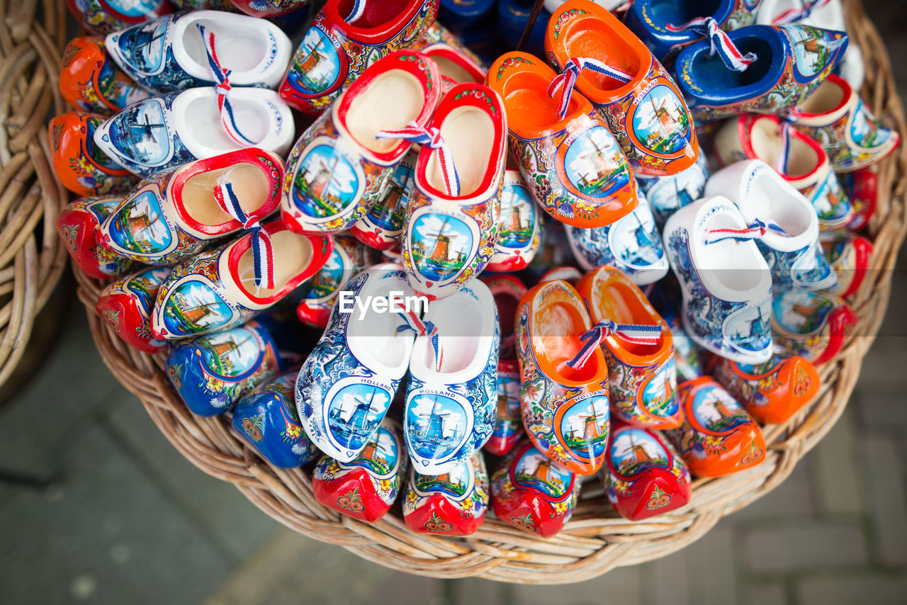 High angle view of colorful clogs shoes in wicker basket for sale at street market