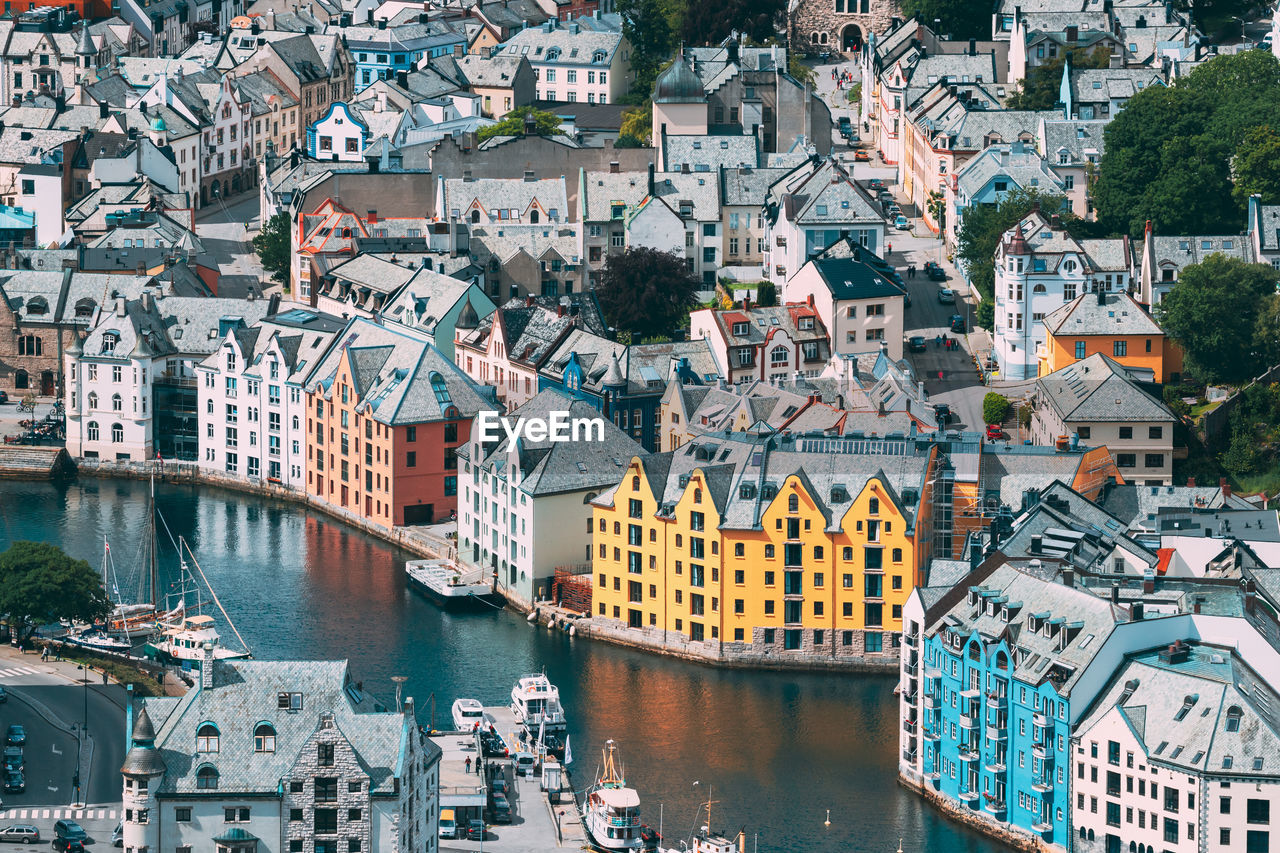 HIGH ANGLE VIEW OF RIVER AMIDST BUILDINGS IN TOWN