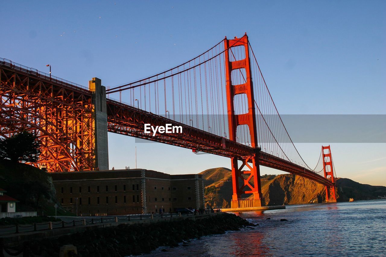 LOW ANGLE VIEW OF SUSPENSION BRIDGE IN CITY