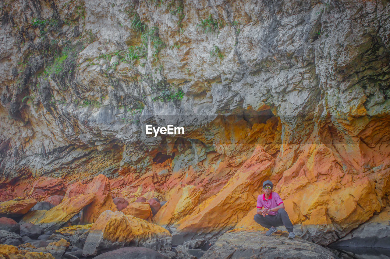 Man crouching on rock